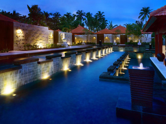 酒店介绍: 1991年开业,2007年装修,共有636间房 Grand Hyatt Bali(巴厘岛君悦酒店),位于努沙杜瓦,这里是巴厘岛知名的旅游度假圣地。酒店离沙努尔、库塔和登巴萨城都很近,出行十分便利。酒店周边环境优美,在湖泊、花园和六个游泳池的围绕下,这座巴厘岛风格的建筑可以说是一座水上宫殿,极富自然美和现代美。 豪华的酒店宽敞明亮,在自然美景的映衬下格外美丽,在夜晚灯光的环绕中又具有另一种美感。客房包括豪华海滨别墅、豪华套间、海景房等,巴厘风格的建筑和装饰品可在房内随处见到,比如传统石雕作品和本